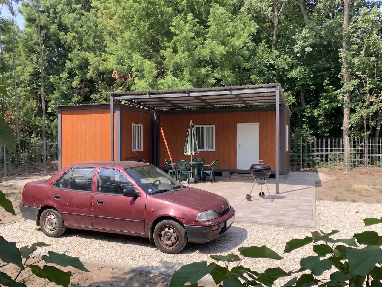 Famintás konténer hétvégi ház pergolával árnyékolt, burkolt teraszán kerti asztallal, székekkel és grillel