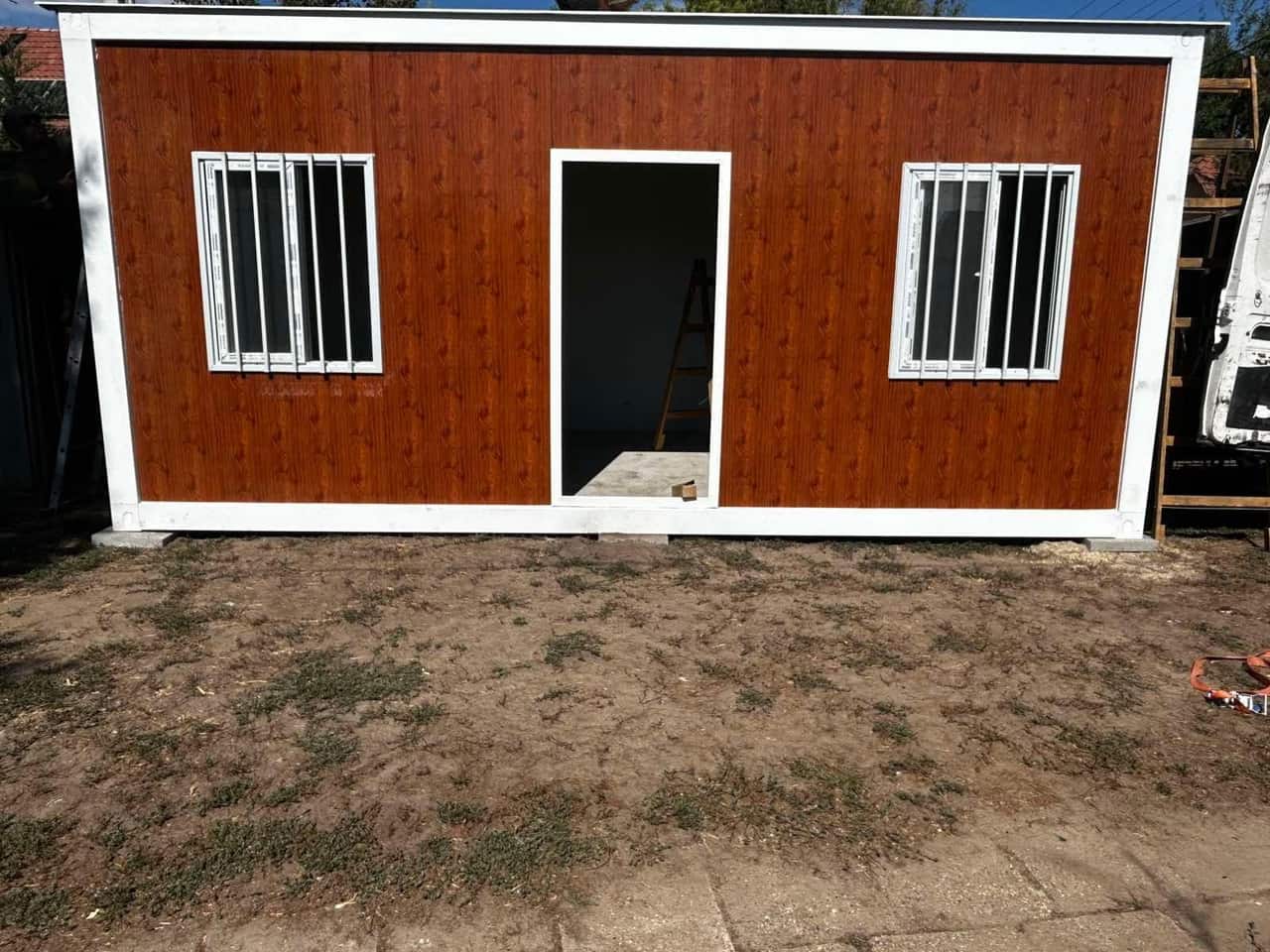 Famintás, fehér keretes 18 m²-es konténerház elölről, telepítés közben